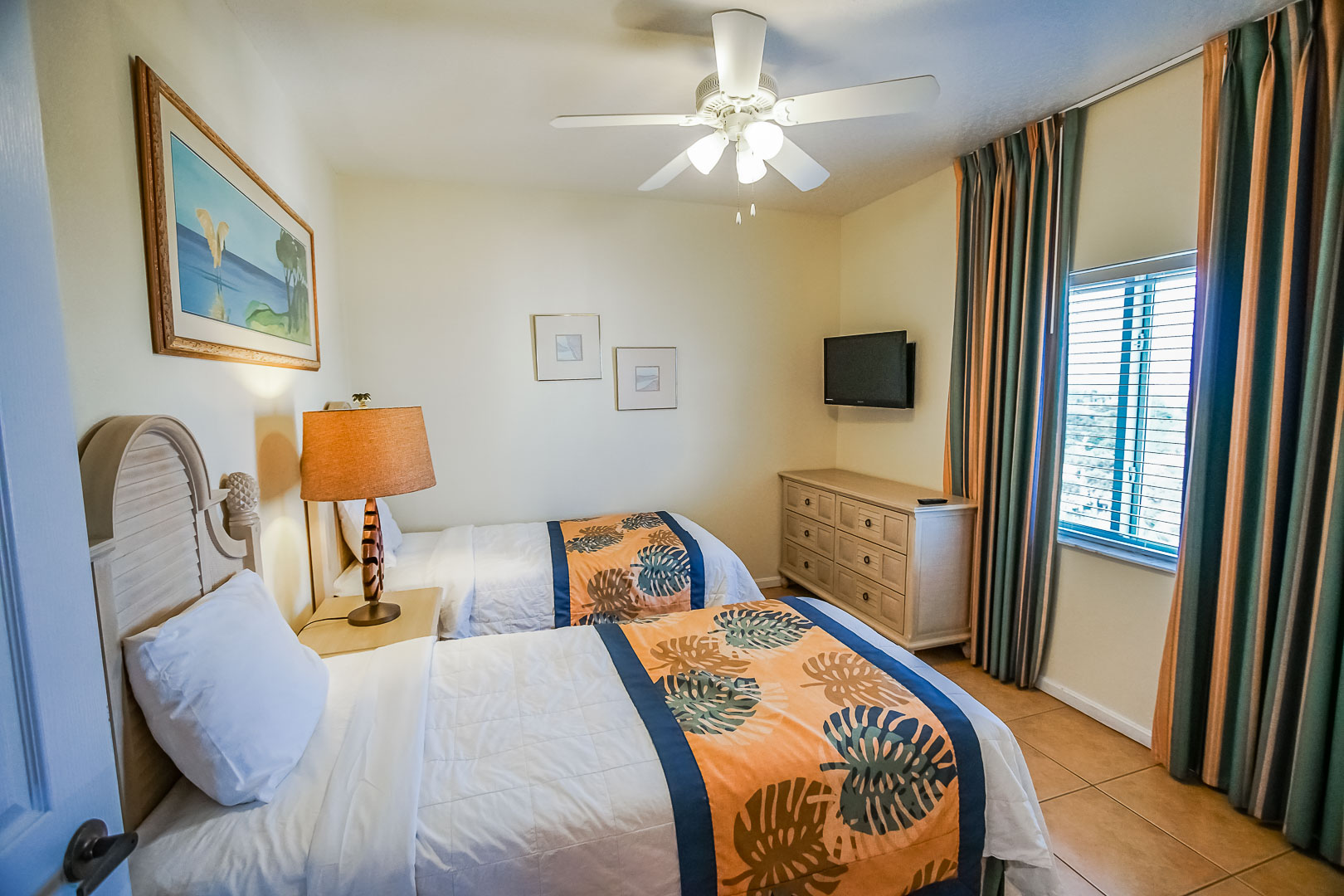 A bedroom with double beds at VRI's Discovery Beach Resort in Cocoa Beach, Florida.